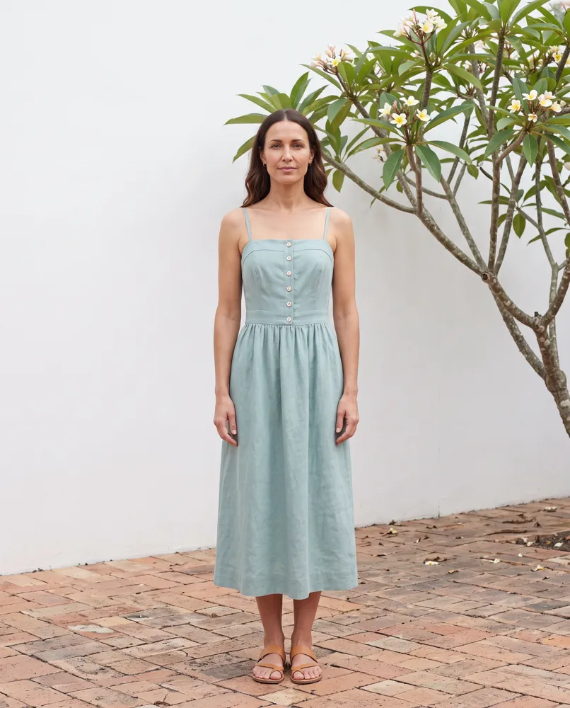 Nell in the green dress, full length, in a white courtyard