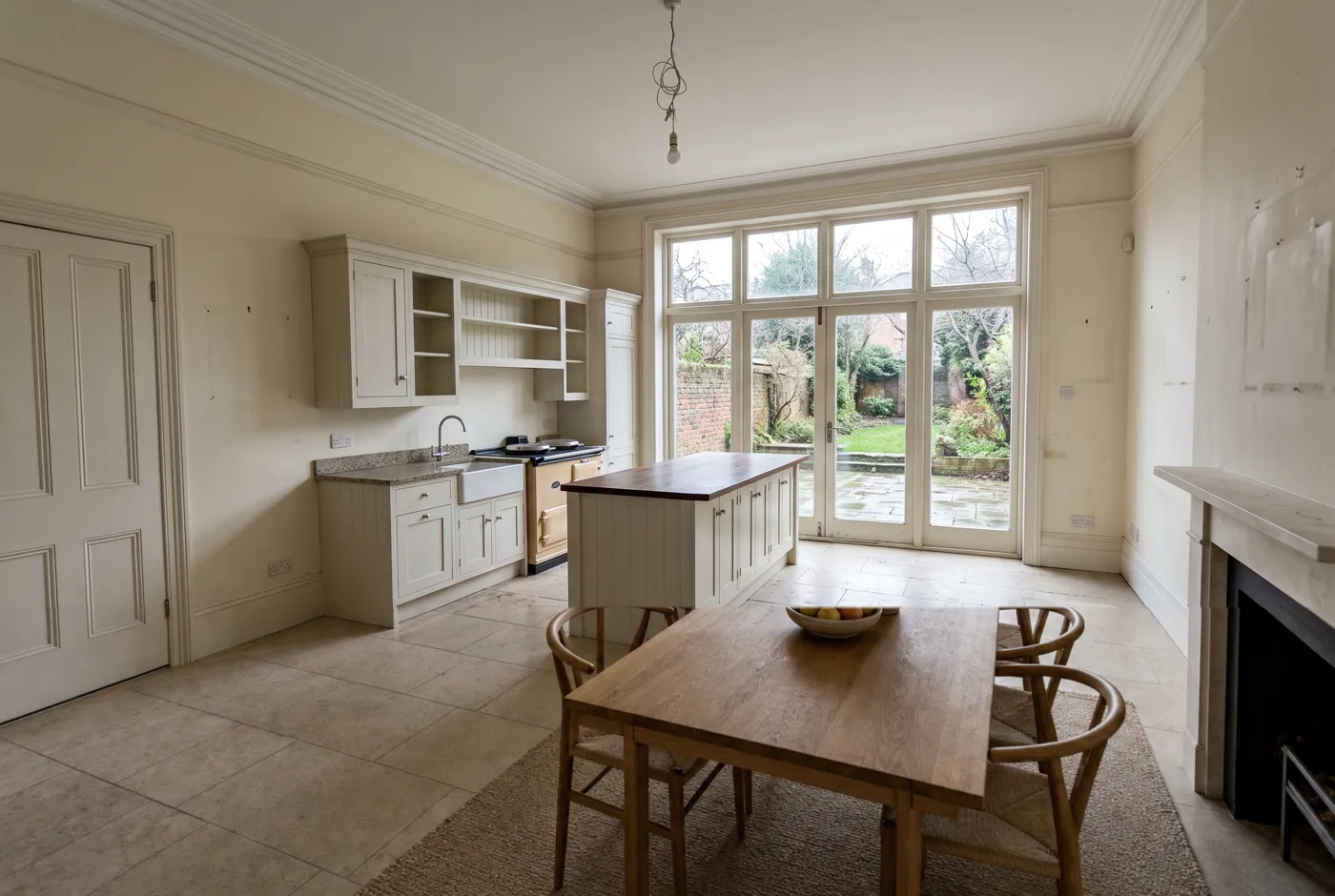 The same kitchen-diner furnished, with an oak dining table, chairs and a rug